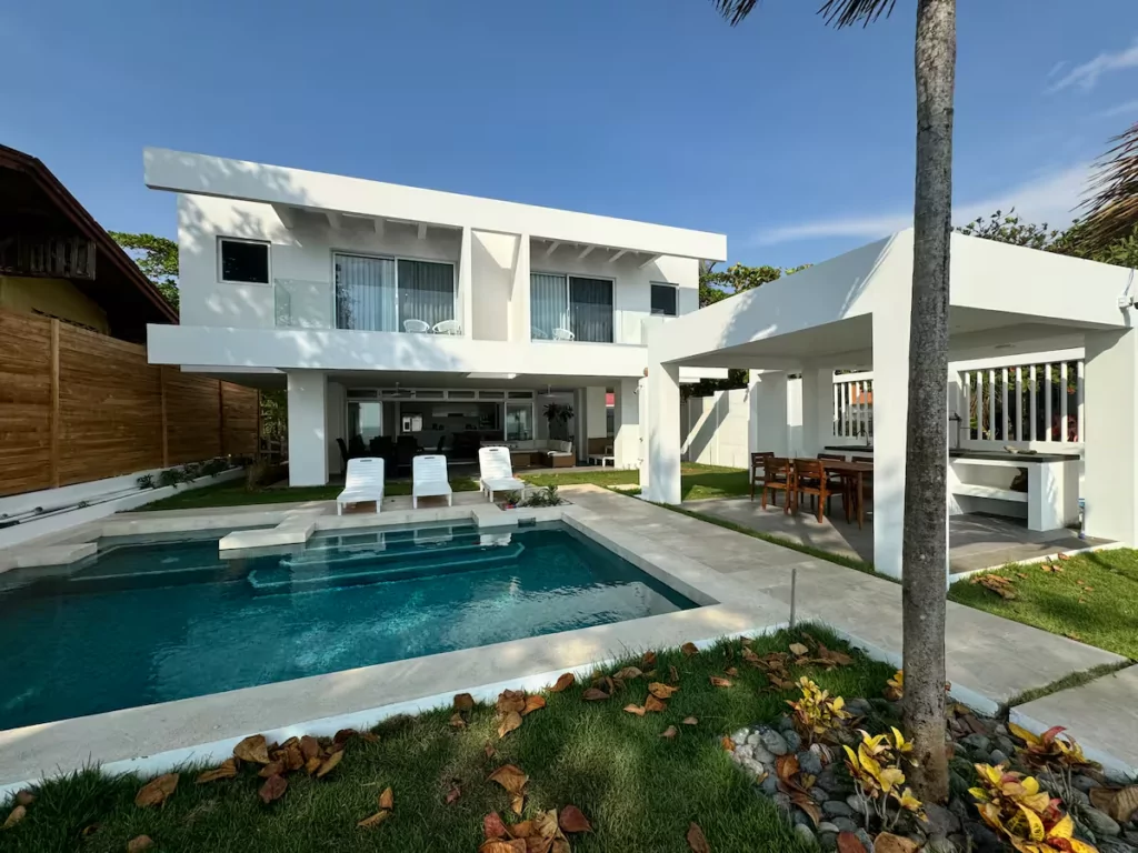 Casa de playa moderna en blanco con piscina, a pocos pasos de la arena en Tivives